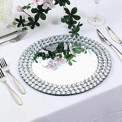Elegant round mirror with crystal accents on a dining table setting.