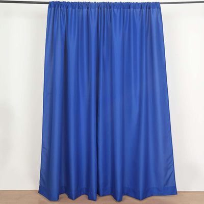 Blue curtain panel hanging on a rod against a neutral backdrop.