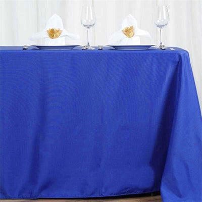 Blue tablecloth with elegant white napkins and wine glasses set for dining.
