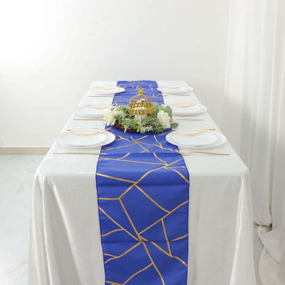 Blue table runner with gold geometric design on a white table setting.