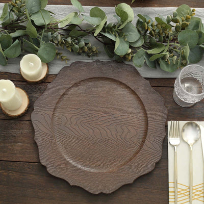 Rustic wooden charger plate on a dining table with greenery and candles.