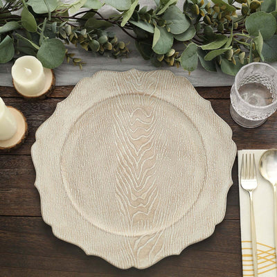 Decorative wooden charger plate on a rustic table setting with greenery.