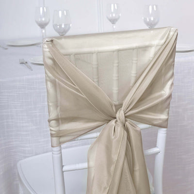 Elegant beige chair sash tied in a bow on a white chiavari chair.