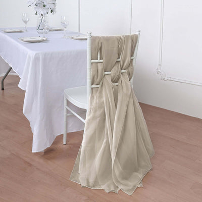 Elegant beige chair sash draped over a white chair at a dining table.