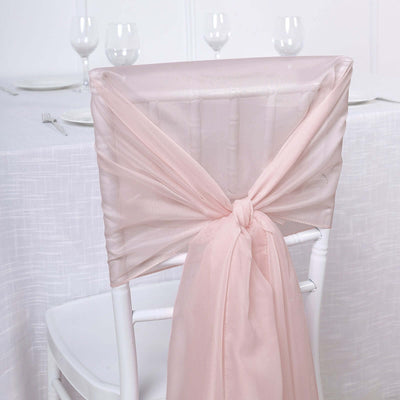 Pink chair sash tied elegantly on a white chair at a dining table.