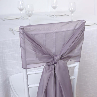 Lavender chair sash tied elegantly on a white chair at a dining table.
