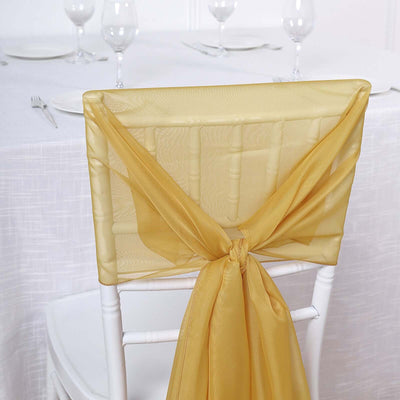 Gold chair sash tied elegantly on a white chair in a dining setup.