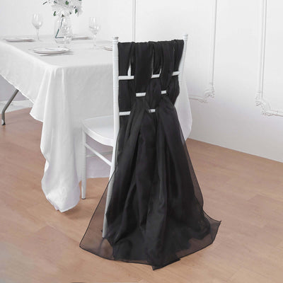 Black chair sash draped on a white chair at a dining table.