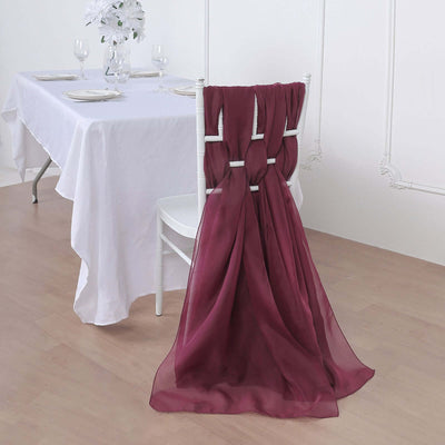 Burgundy chair sash draped elegantly on a white chair in a dining setting.