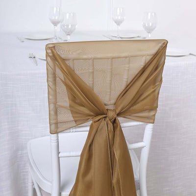 Gold chair sash tied on a white chiavari chair at a dining table.