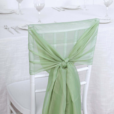 Green chair sash tied elegantly on a white chair in a dining setting.