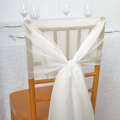 White chair sash tied in a bow on a wooden chair against a white backdrop.