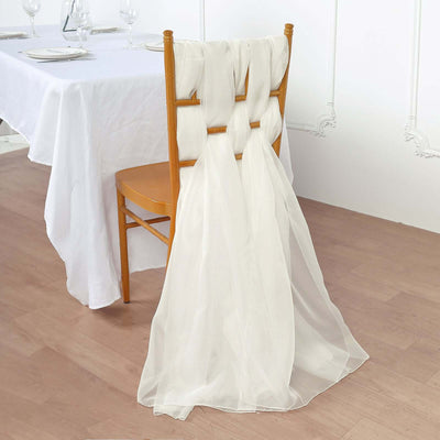 Elegant sheer chair sash draped on a wooden chair in a dining setting.