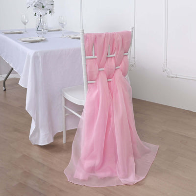 Pink chair sash draped elegantly on a white chair at a dining table.