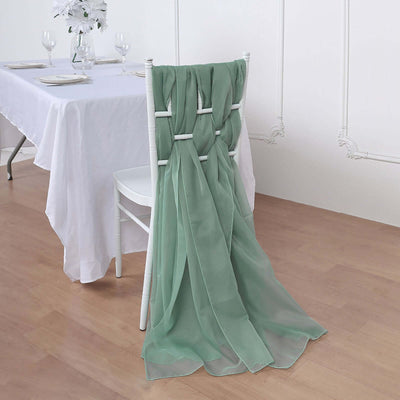 Green sheer chair sash draped elegantly on a white chair in a dining setting.