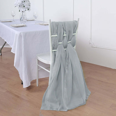Elegant gray chair sash draped over a white chair at a dining table.