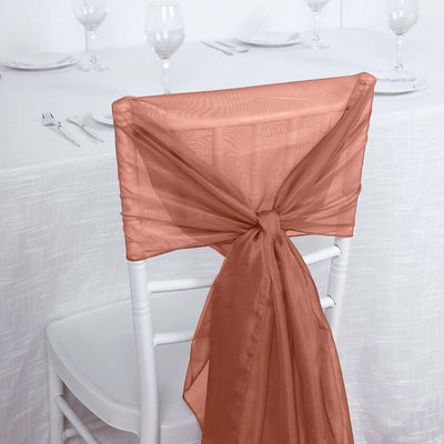 Peach organza chair sash tied on a white chair at a dining table