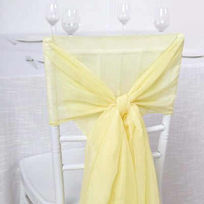 Yellow chair sash tied elegantly on a white chair against a plain backdrop.