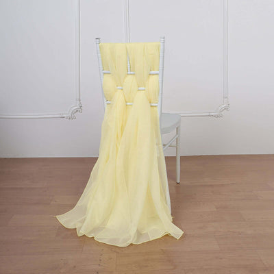 Yellow sheer fabric draped over a white chair in a studio setting.