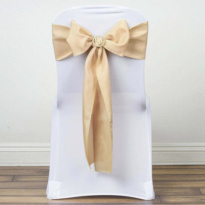 Gold satin chair sash bow on a white chair.