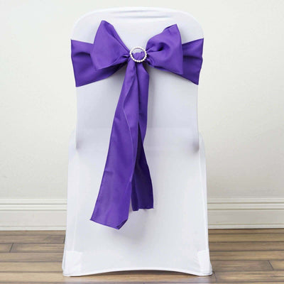 Purple satin chair sash with rhinestone buckle on a white chair.