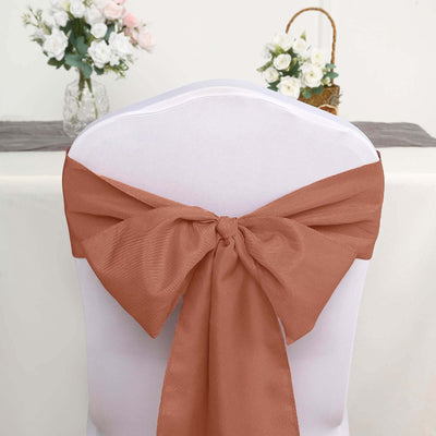 Rust-colored chair sash tied in a bow on a white chair.