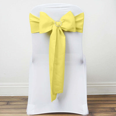 Yellow chair sash bow on a white chair against a plain backdrop
