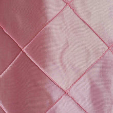 a close up of satin & taffeta chair sashes made of quilted fabric in pink