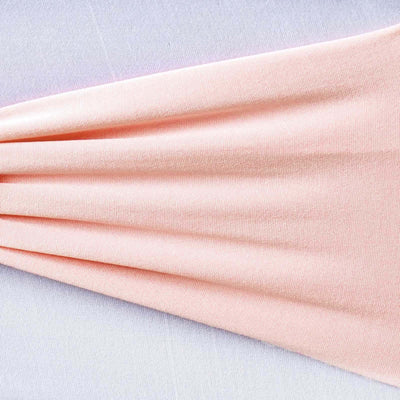 Peach-colored fabric draped elegantly on a light background.