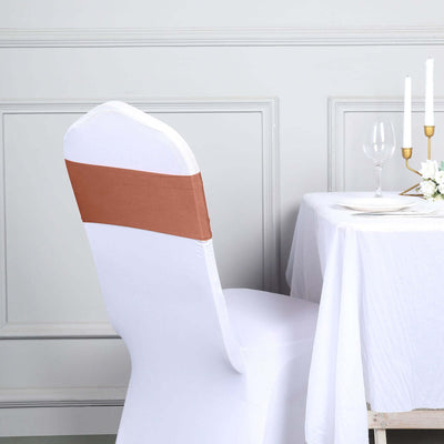 White chair cover with brown sash in elegant dining setting.