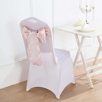 White chair cover with pink satin bow on a wooden floor.