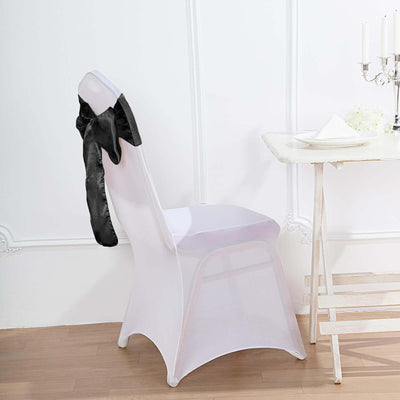 Elegant chair cover with black sash, styled for an event setting.