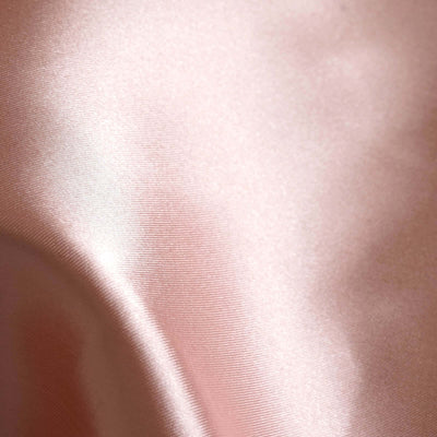 Soft pink satin fabric texture close-up.