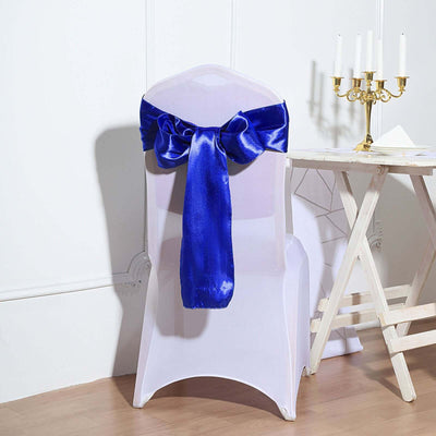 White chair with a blue satin bow on the back, studio-style shot.