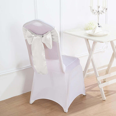 Elegant white chair cover with bow detail, perfect for events and weddings.