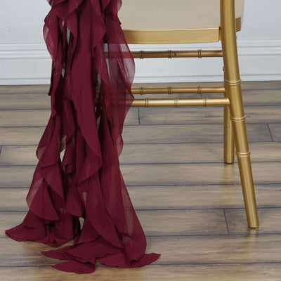 Burgundy chiffon fabric draped elegantly over a gold chair leg.