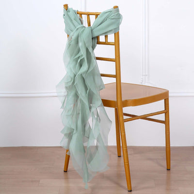 Mint green chiffon scarf draped over a wooden chair.