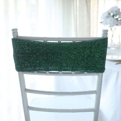Green beaded chair back decor on a white chair.