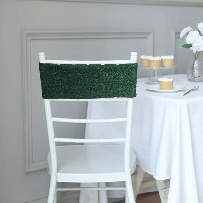 Green chair back cover on a white chair in a dining setting.