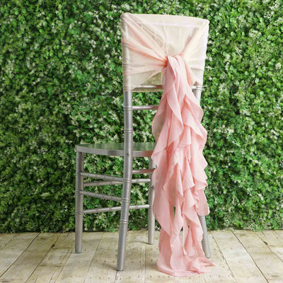 Silver chiavari chair with pink ruffled sash against a greenery backdrop.