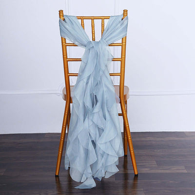 Light blue chiffon chair sash draped over a gold chiavari chair.