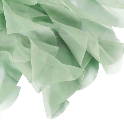 Green sheer fabric pieces layered together, showcasing a soft, flowing texture.