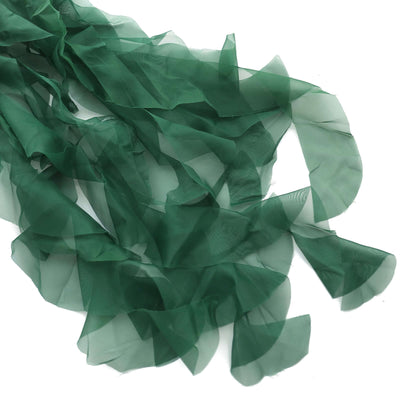 Green chiffon fabric draped elegantly on a white background.
