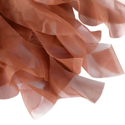Sheer rust-colored fabric draped elegantly on a white background.
