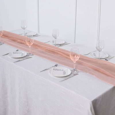Elegant table setting with pink runner and glassware.