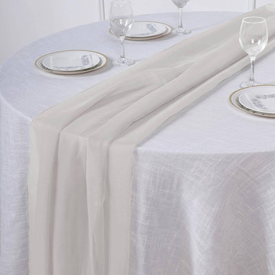Elegant sheer table runner draping over a round table setting.