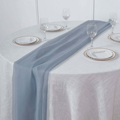 Elegant blue table runner on a white table with plates and glasses.