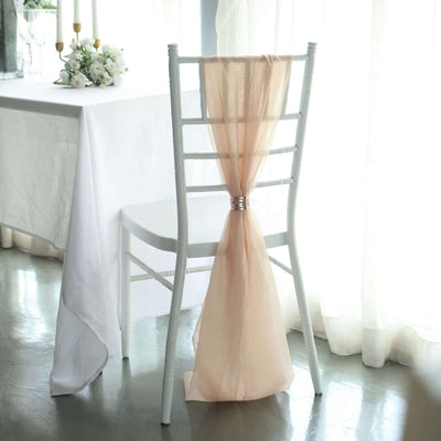 Elegant white chair with soft peach drape, perfect for weddings and events.