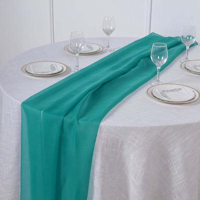 Turquoise table runner draped elegantly over a round table setting.