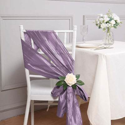 Purple chair sash with floral accent on a white chair in a dining setting.